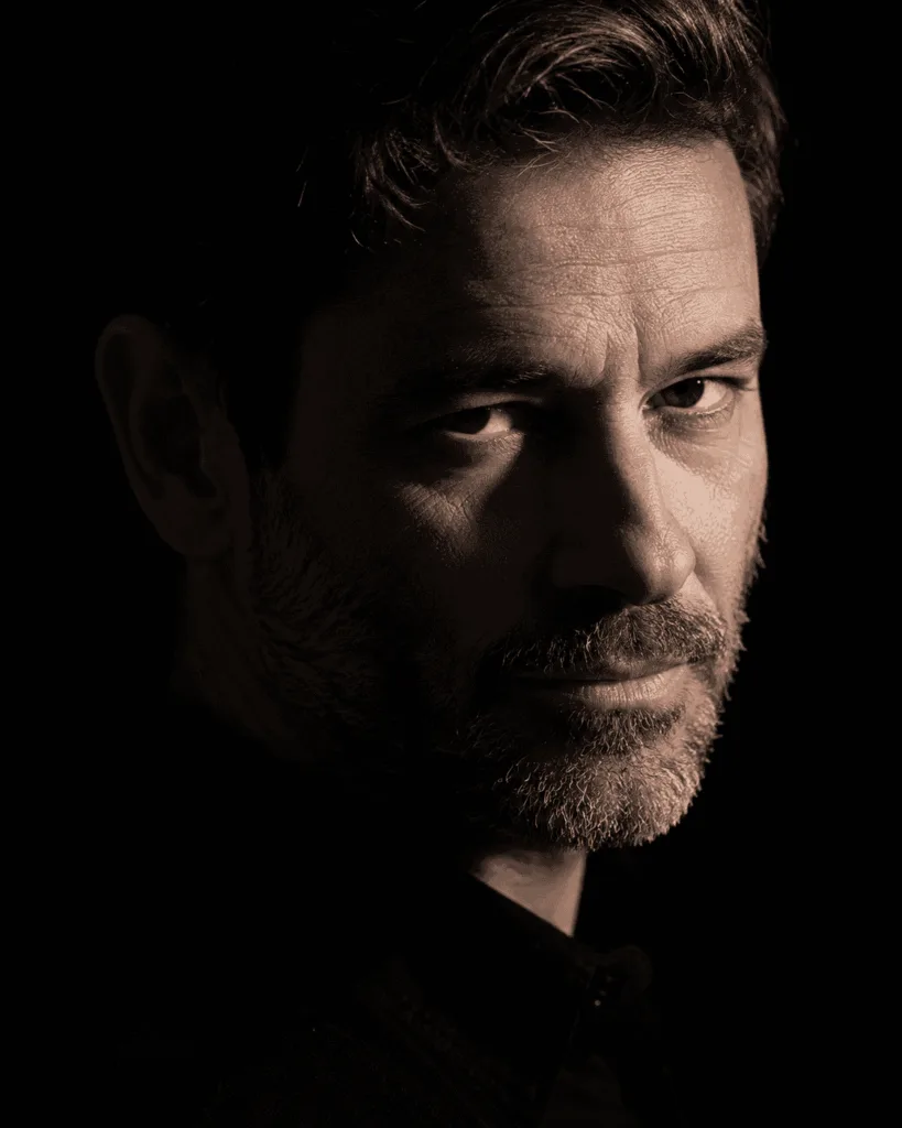 retrato masculino low key fotorrealista de um homem de 45 anos com barba curta Prompts Claude para Fotografia 